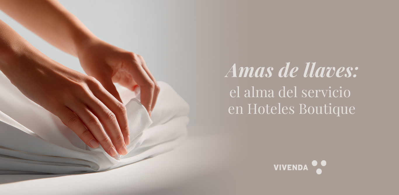 otografía de ama de llaves alisando una cama blanca en un hotel boutique, transmitiendo hospitalidad, atención al detalle y textiles Vivenda.