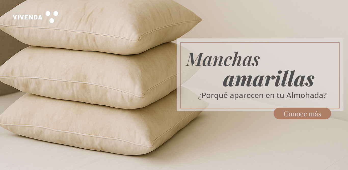 Primer plano de almohada de plumas con funda de algodón limpia en cama beige, representación de cuidado textil y prevención de manchas amarillas.